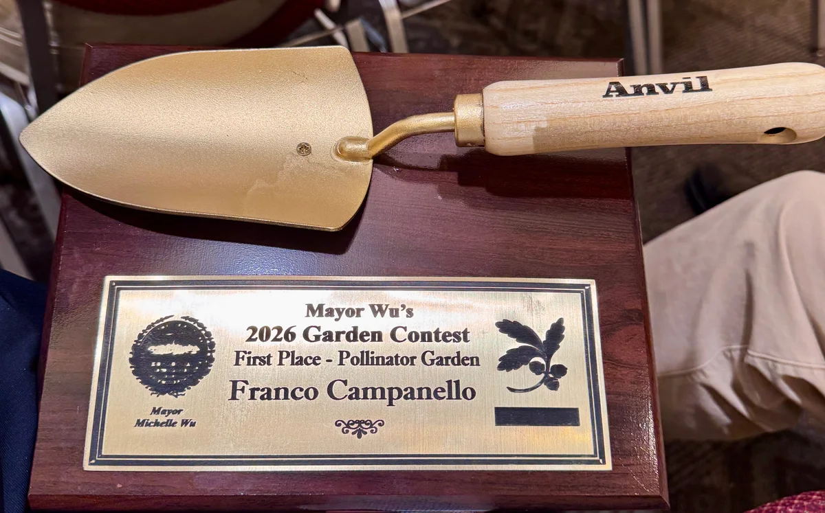 A golden garden trowel mounted above a plaque reading Mayor Wu’s 2026 Garden Contest, First Place — Pollinator Garden, Franco Campanello