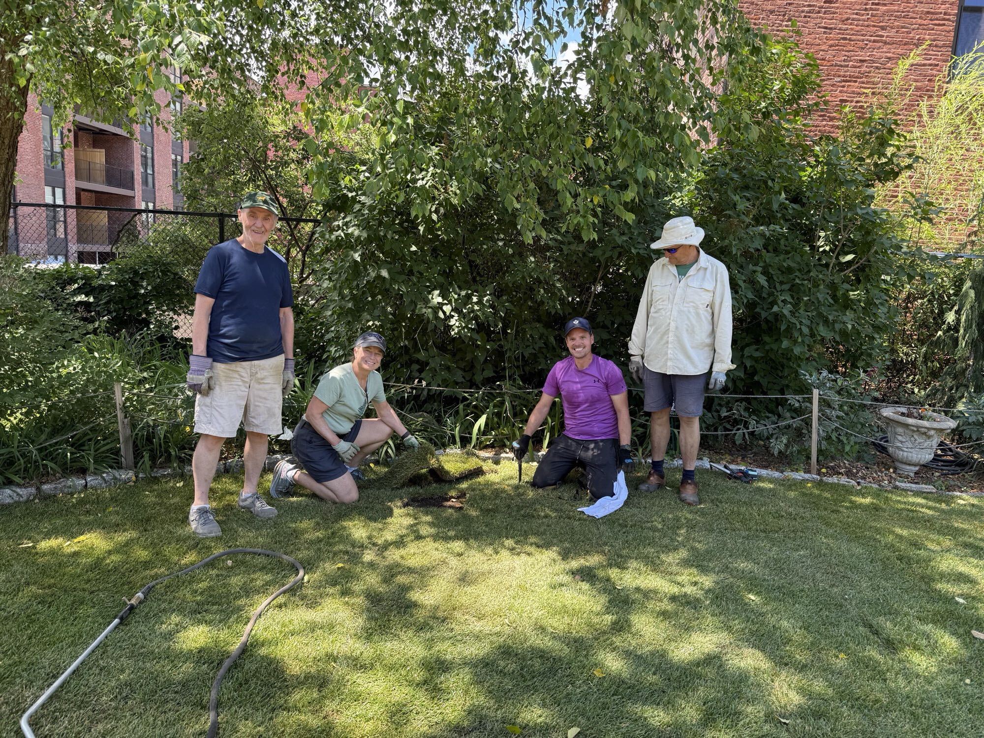 Four volunteers gathered in the freshly sodded Round Window Garden