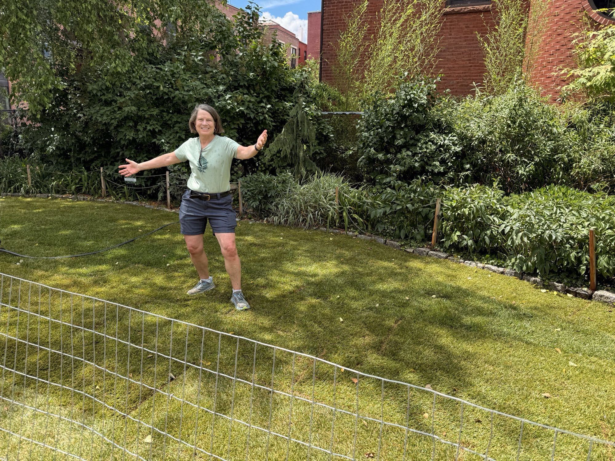 Board member celebrating on the newly finished lawn, arms outstretched